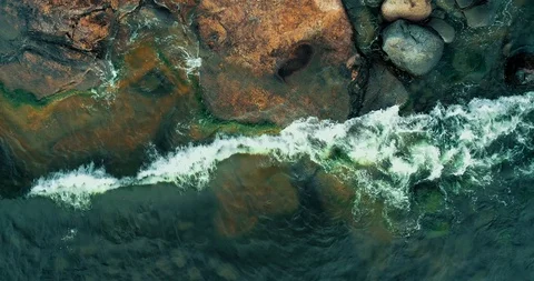 Really low above cliffs at the coast of Helsinki Finland looking at waves Stock Footage 98106946