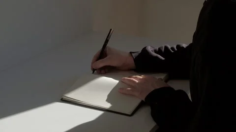 Realtime footage of man openning the diary and starting to write text with pen Video stock 229896285