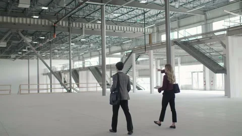 Realtor and client touring large empty warehouse Stock Footage 221035247