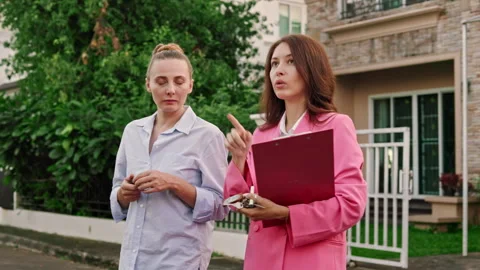 The realtor and her client exchanged thoughts and opinions as they surveyed the Stock Footage 246383190