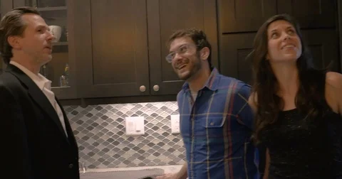 Realtor explaining a modern kitchen to a perspective buying couple Stock Footage 82273736
