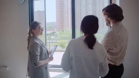 Realtor Opens Window as Young Couple Admire Their New Flat Video stock 311823518