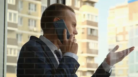 Realtor talking on the phone while standing on the balcony of the house Stock Footage 205086790