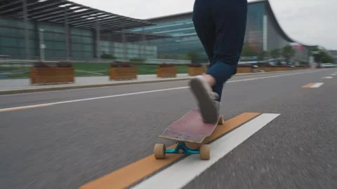 Rear and Side Tracking Shot of Woman Riding Longboard on Urban Street Stock Footage 305619617