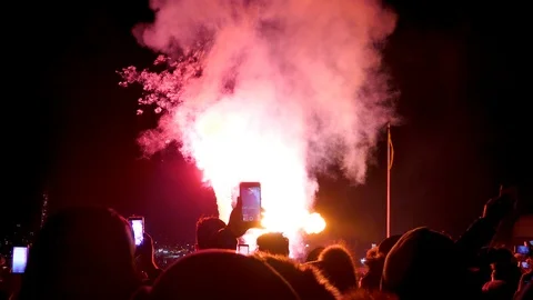 Rear back shot crowd of silhouette people filming fireworks with mobile phones Stock Footage 112079222