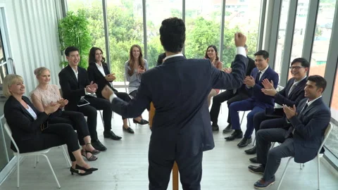 Rear back view of businessman standing at podium giving a speech addressing a Stock Footage 162181161