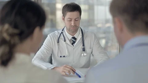 Rear Back View of Couple having Conversation with Middle Aged Doctor Stock Footage 116166597