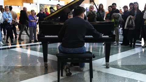 Rear back view of a man playing the piano in a public place Stock Footage 273475425