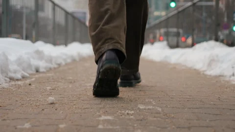 Rear back view man walking alone across city street sidewalk on winter day Stock Footage 326827028