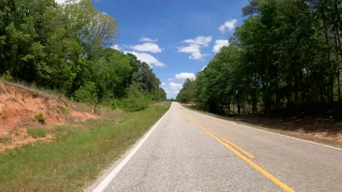Rear car POV distant traffic long road and farmland puffy clouds and blue sky Stock Footage 185203813