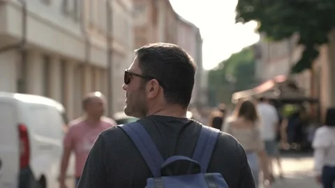 Rear of handsome hipster with backpack walking in old town Stock Footage 186561333