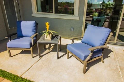 Rear Patio With Small Table &amp; Two Arm Chairs With Blue Cushions Stock Photos