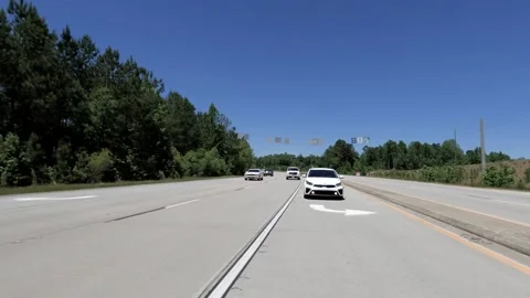 Rear POV lite traffic changing lanes clear blue sky beautiful summer day Stock Footage 238390563