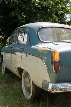 Rear Profile View of Weathered Two Tone Soviet Car in Sunlit Park Stock Photos