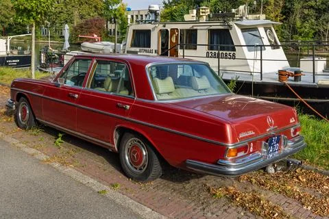 Rear side view of a classic red Mercedes-Benz 280 SE 4.5 parked near a canal, Stock Photos