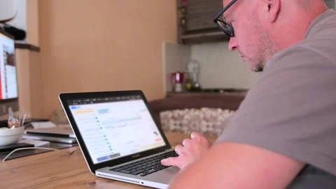 Rear side view focused man mobile developer is typing on laptop at home office. 스톡 동영상 243583509