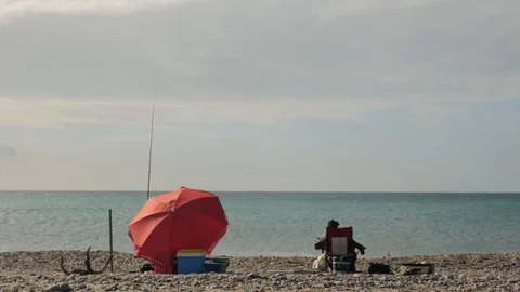 Rear static view of two fishermen with rod on a beach Stock Footage 121614439
