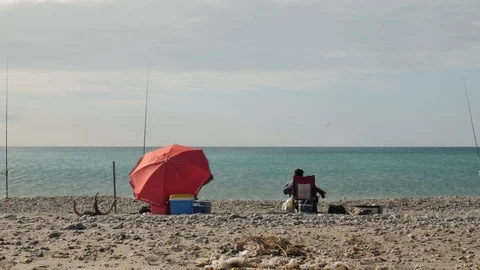 Rear static view of two fishermen with rod on a beach Stock Footage 121614730