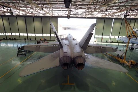 Rear top view of twin engine fighter jet in maintenance hangar Stock Photos