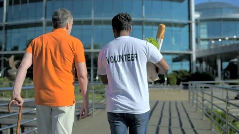 Rear view of an active volunteer helping a senior man Stock Footage