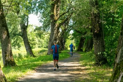Rear view on active young man running during the triathlon competition. Stock-Fotos