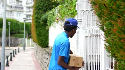 Rear view of an african courier delivering a package Stock Footage 284420348