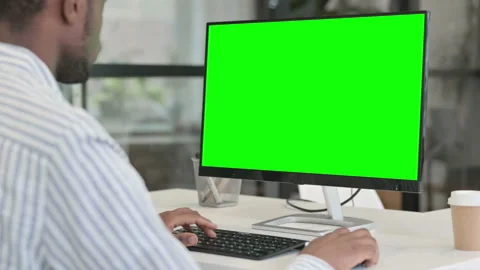 Rear View of African Man using Desktop with Green Chroma Key Screen Video stock 154361895