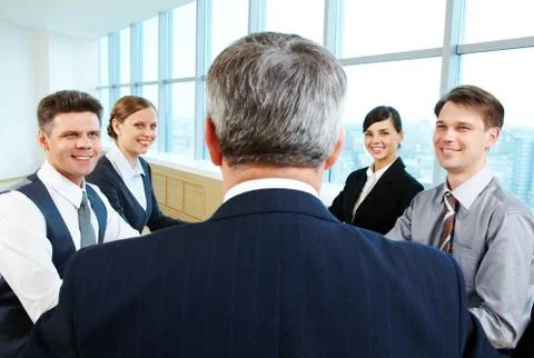 Rear view of aged businessman making report to partners at conference Stock Photos