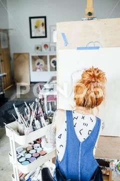 Rear view of artist drawing sketch on canvas in studio Stock Photos