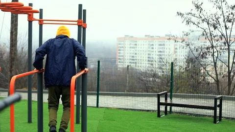 Rear view of athlete man doing exercises on pull-up horizontal bar outside enjoy 스톡 동영상 166090561