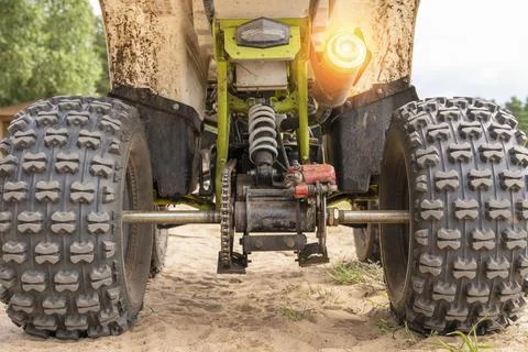 Rear view of the ATV standing on sandy ground Photos