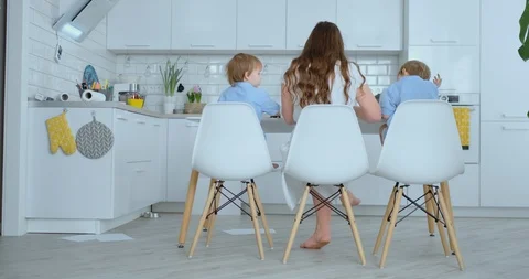 Rear view, back. Two children of boys and mother are engaged in creative Stock Footage 105111443