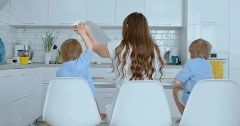 Rear view, back. Two children of boys and mother are engaged in creative Stock Footage 105112465