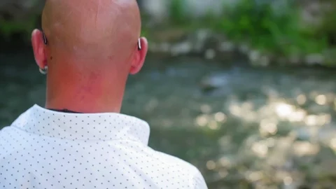 Rear view of a bald man looking at a river flowing under a bridge. Close up shot Stock Footage 115032352