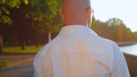 Rear view of bald man walking in a park and looking ahead. Close up shot. Stock Footage 112831433
