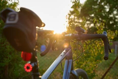 Rear view of bicycle with front and rear lights at sunset Stock Photos