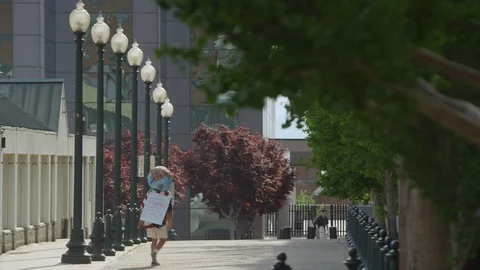 Rear view of boy with globe walking on the city lane Stock Footage 103429312