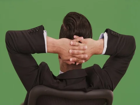 Rear view of businessman leaning back in office chair on green screen Stock Footage