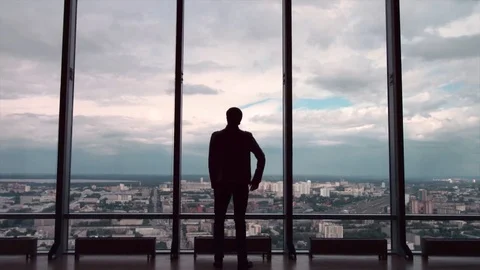 Rear view of businessman in an office with panoramic city view. Businessman Stock Footage