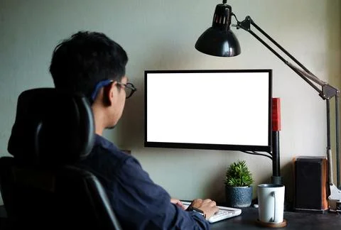 Rear view businessman working with computer while sitting in modern workplace Stock Photos