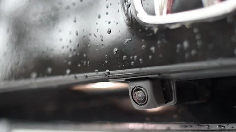 Rear view camera on a black car. Drops on the paint. Stock Footage 164998718