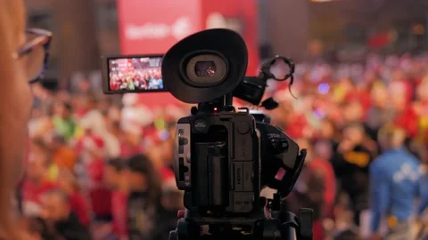 Rear view of a camera man filming in a busy pedestrian area of a historical city Stock Footage 141472116