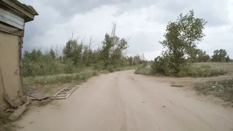 Rear view of car driving along a rural dirt road Stock Footage 75834872