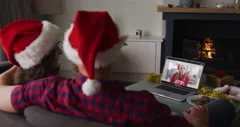 Caucasian father and two sons wearing santa hats having a