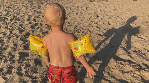 Rear view of a child walking on the sand Stock Footage 158118214