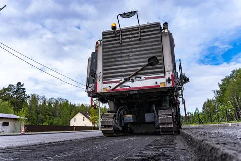Rear view of a cold milling machine and cut asphalt on the road Stock Photos