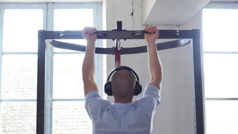 Rear view of company worker in suit doing pull ups. Handsome caucasian man in Video stock 145557341