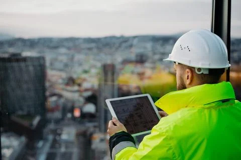 Rear view of construction site manager using digital tablet to inspect building Stock Photos