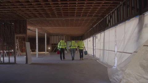 Rear View Of Construction Workers Walk Together Carrying Equipment Stock Footage 270389554