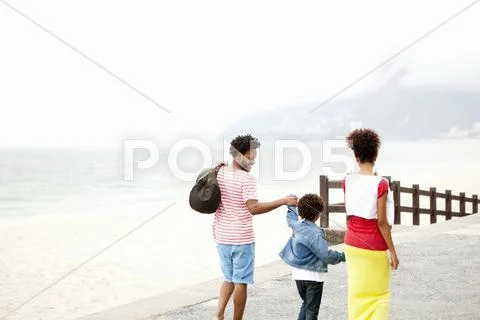 Rear View Of Couple And Son Strolling Hand In Hand, Ipanema Beach, Rio De